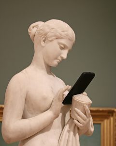 Statue qui navigue sur un mobile à la recherche d'informations